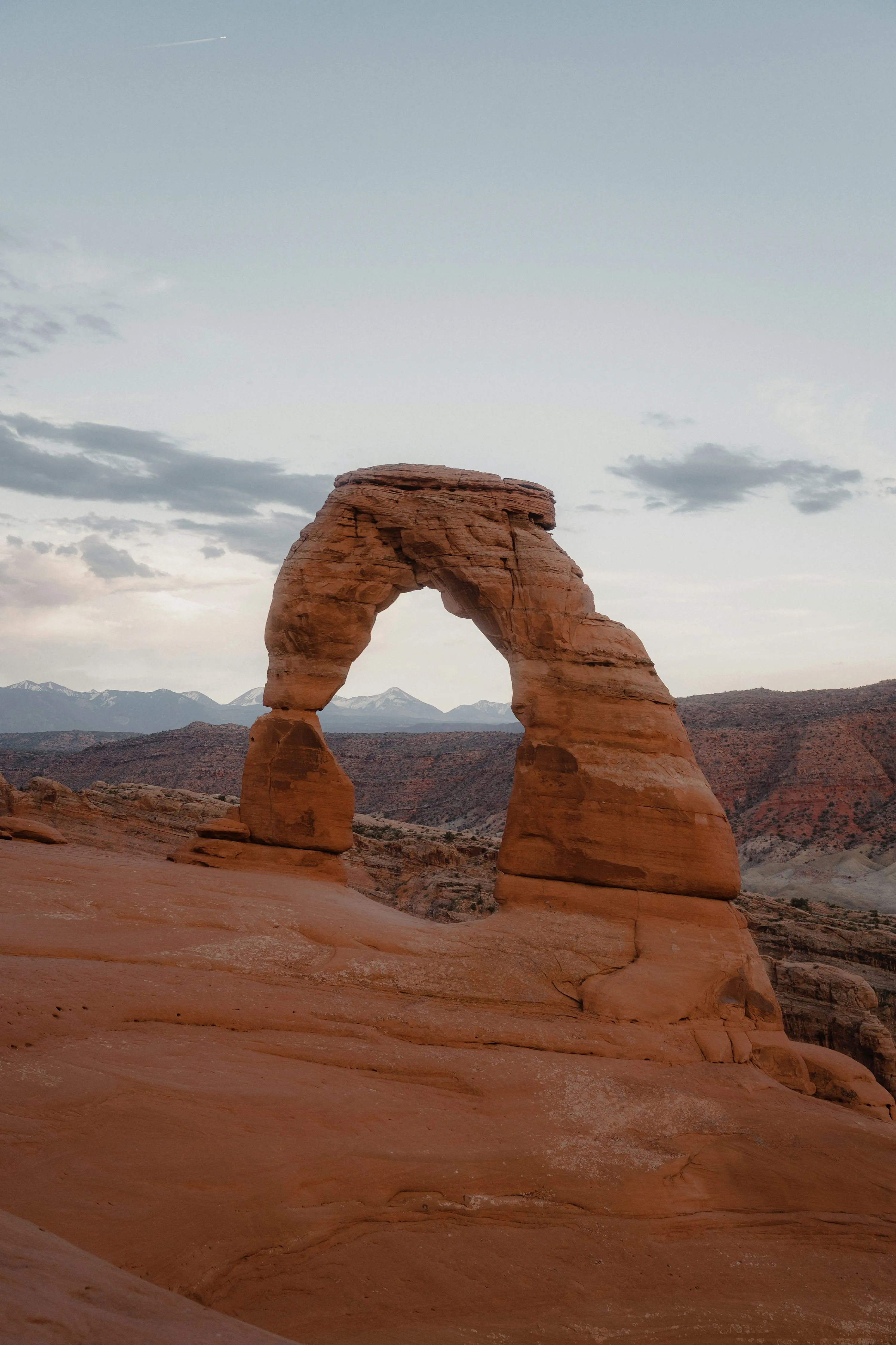 Dramatic red sandstone arch formation in Utah desert at golden hour