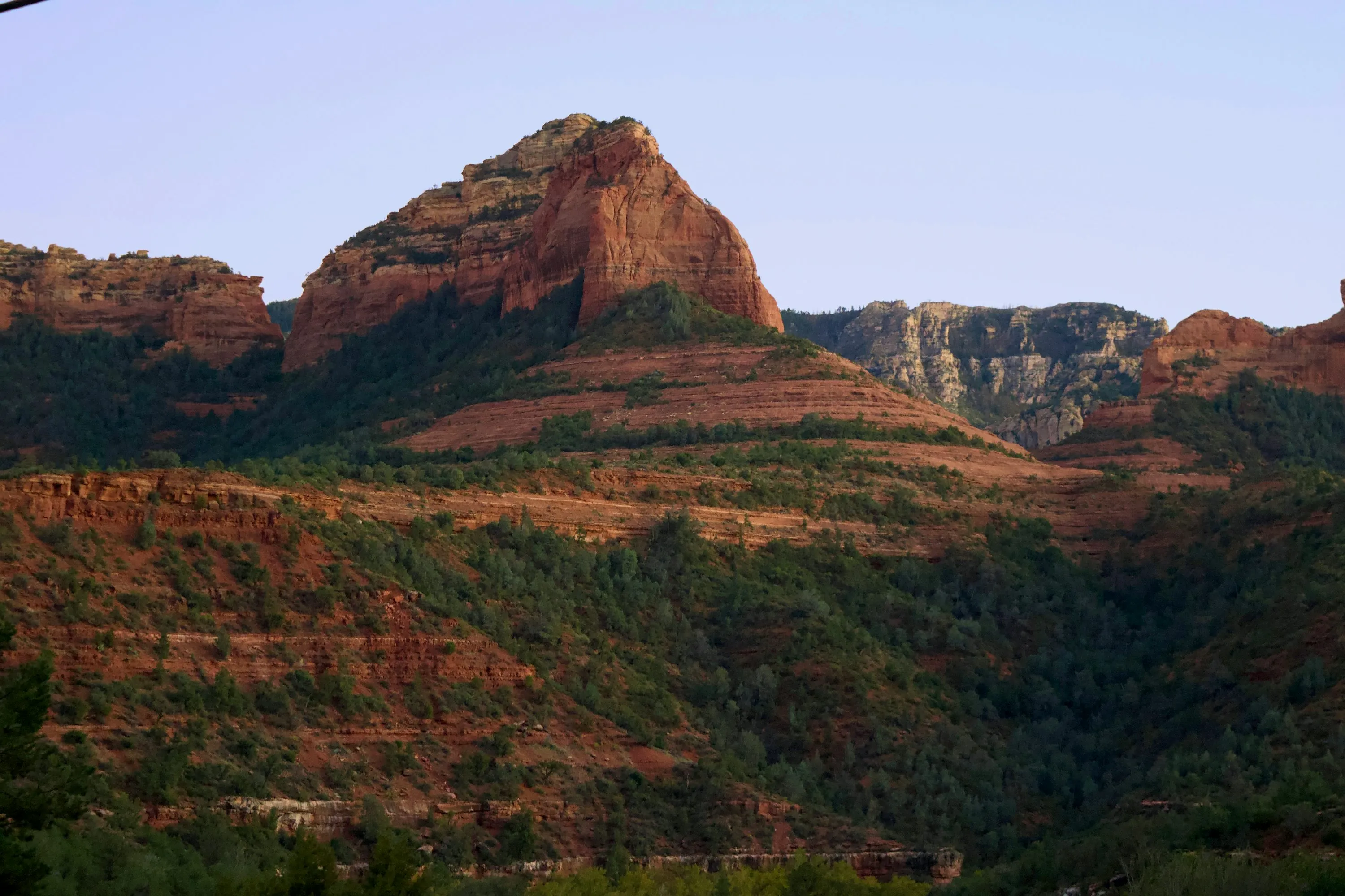 Dramatic red sandstone buttes rising above Arizona desert scrub at golden hour